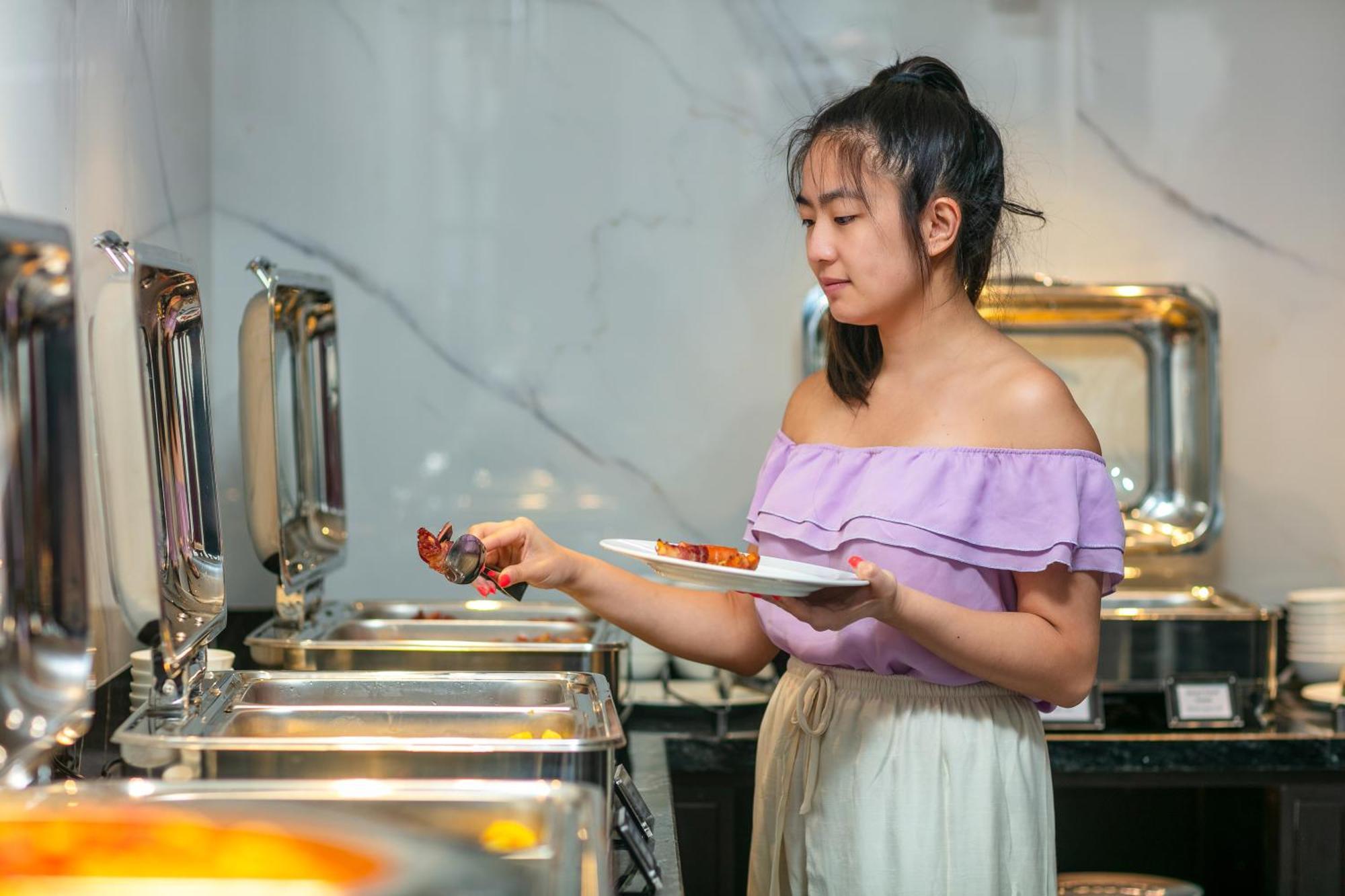 فندق ماي دي فيل أولد كوارتر هانوي المظهر الخارجي الصورة A woman serving herself at a buffet